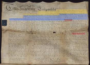 A large rectangular sheet of parchment is inscribed with neatly ruled lines of text in dark brown ink; at the upper left, the title of the deed is surrounded with curlicued embellishments. Blocks of color highlight different legal components of the deed’s contents.